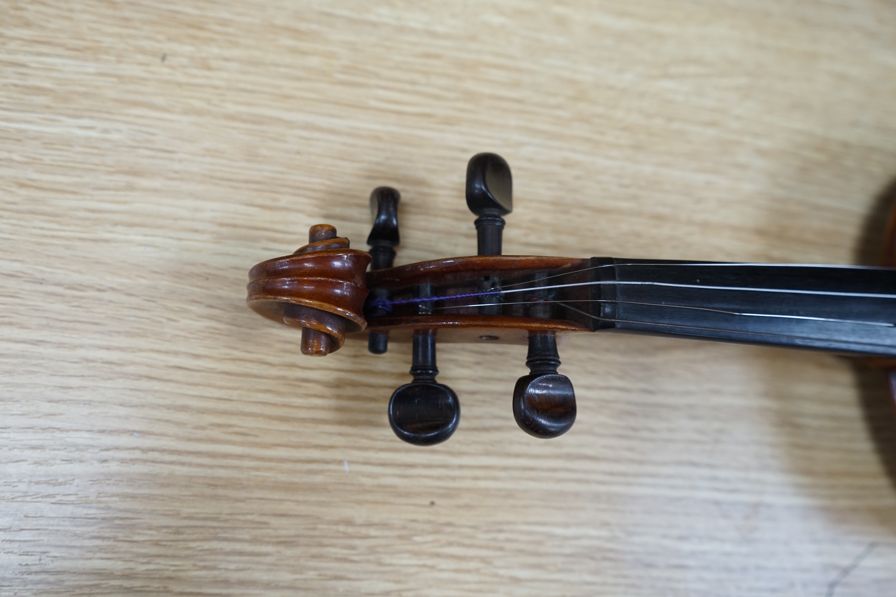 A cased early 20th century violin with bow, no label, back measures 35.5cm. Condition - fair to good